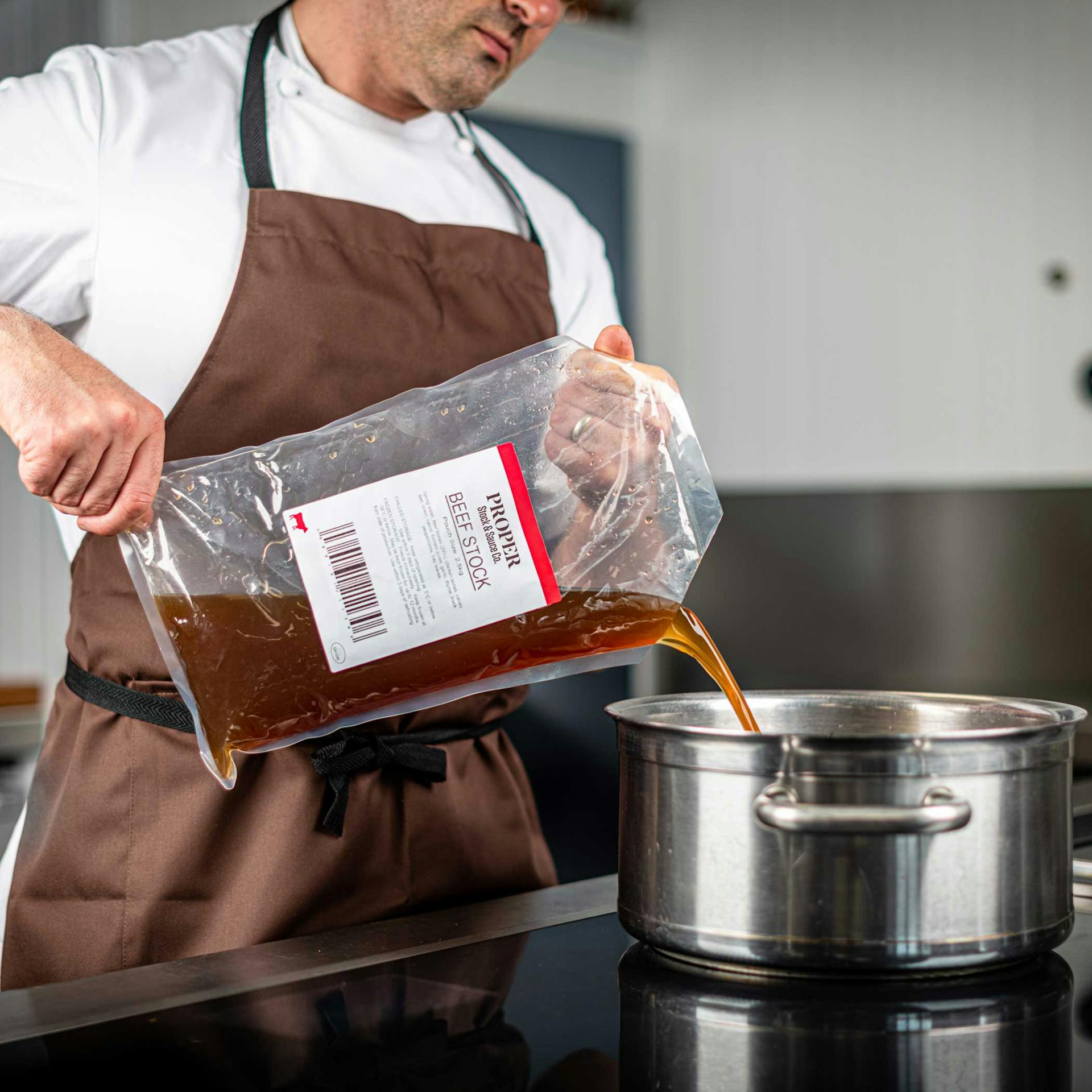 Chef pouring stock into pot